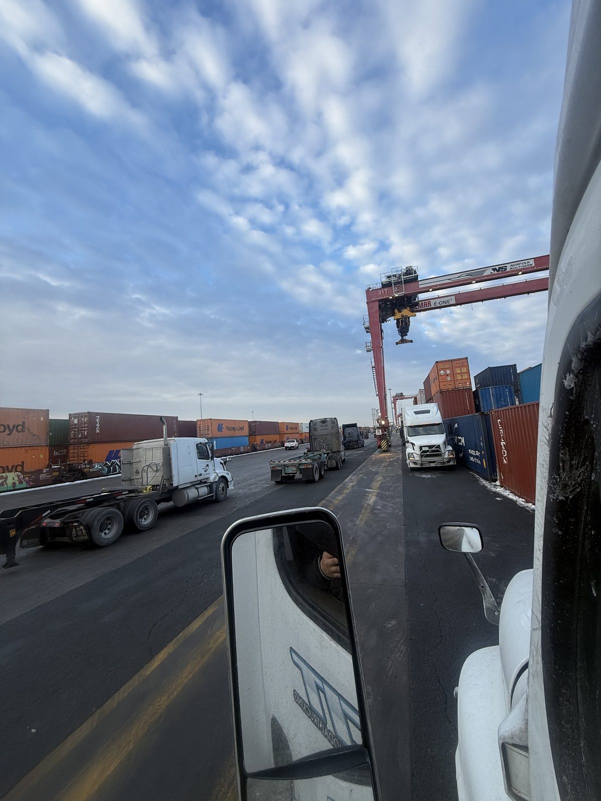View from a CIT tractor cab down a rail terminal lane, CIT lettering in the door mirror
