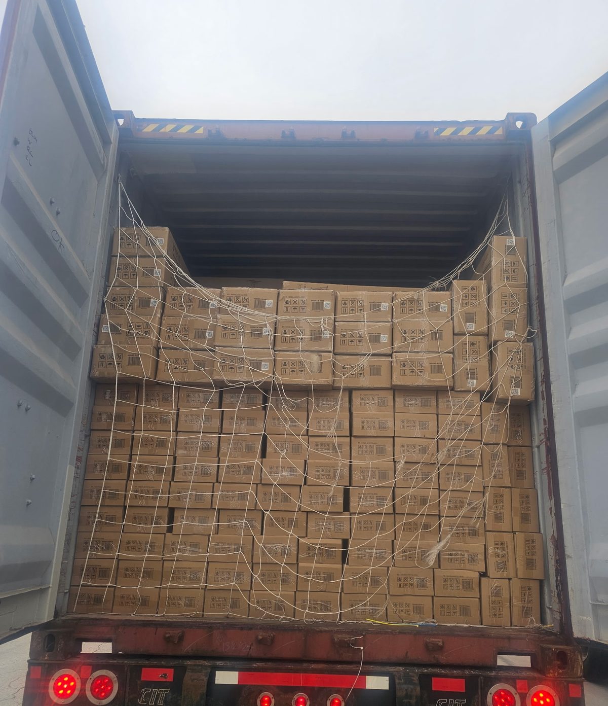 Loaded ocean container secured with a cargo net on a CIT chassis